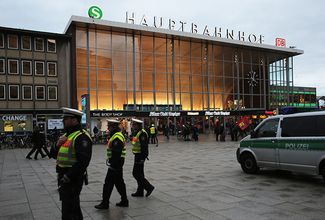 Сотрудники немецкой полиции патрулируют здание вокзала в Кельне. 11 января 2016 года