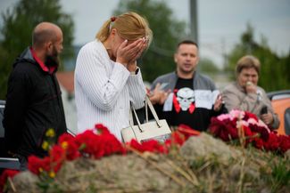 Женщина плачет у импровизированного мемориала рядом с бывшим «ЧВК Вагнер Центром» в Санкт-Петербурге