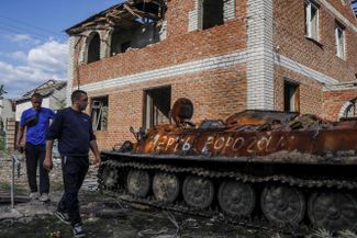 Мужчина осматривает свой разрушенный дом в селе Малая Рогань. Рядом с домом — уничтоженная российская боевая техника. Село отбито украинскими войсками.