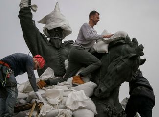 Волонтеры укрывают мешками с песком памятник гетману Запорожского казачества Петру Сагайдачному в Киеве.