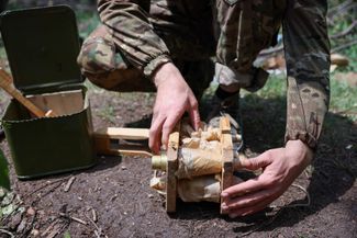Российский военный распаковывает боеголовки для снарядов РСЗО «Град»
