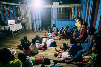 Вечерний просмотр телевизора в поселке тикуна Сан Мартин де Амакаяку, Колумбия