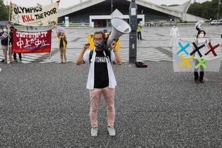 Протестующие против Олимпиады возле одного из олимпийских объектов в Токио, 9 июля 2021 года. 