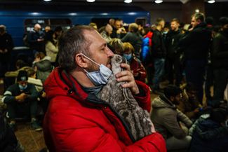 Житель Харькова пытается успокоить кота. Во время обстрела он и еще тысячи харьковчан прячутся в метро. 24 февраля, 2022 года