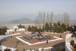 The monument and cemetery at the center of the Ata-Beyit Memorial Complex. The grave of Kyrgyz writer Chingiz Aitmatov can be seen in the background.
