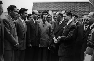 Шах Ирана Мохаммед Реза Пехлеви (третий справа, в костюме в полоску) во время визита в исследовательский институт компании BP в пригороде Лондона. 27 июля 1948 года