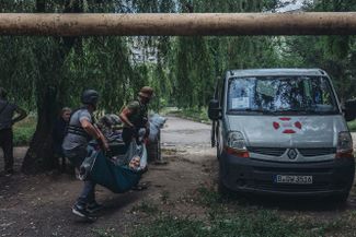 Волонтеры благотворительного фонда «Восток SOS» помогают эвакуировать пожилую жительницу Торецка. В понедельник, 18 июля, российские войска обстреляли этот город в Донецкой области, погибли шесть человек