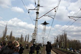 Украинский истребитель МиГ-29 летит над пророссийскими активистами, пока те пытаются блокировать колонну ВСУ в Краматорске — соседнем от Славянска городе. Как и Славянск, Краматорск перешел под контроль сепаратистов 12 апреля