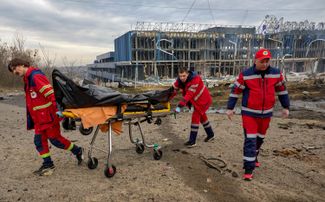 Медицинские работники увозят с места обстрела в Харькове тело погибшего человека. 6 апреля 2024 года
