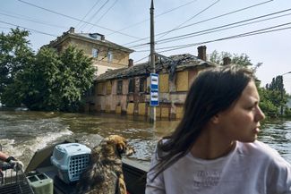 A Kherson resident and her pet evacuate by boat. June 8, 2023.