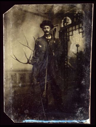 Портрет охотника с ружьем и оленьими рогами в руках