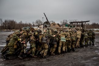 Украинские военные толкают бронетранспортер
