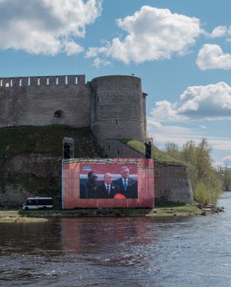 Ivangorod Castle on the Russian side of the Narva River. The Victory Parade in Moscow is broadcast on screen. May 9, 2025
