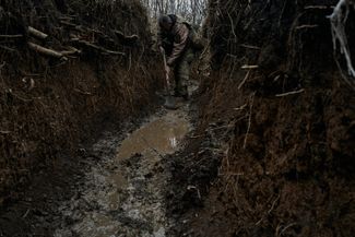 Украинский солдат убирает грязь из окопа. Ноябрь 2023 года.