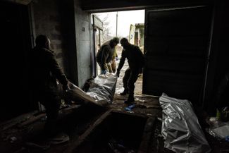 Украинские военные врачи несут тело погибшего солдата ВСУ