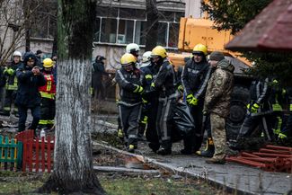 Спасатели несут тело одной из жертв крушения вертолета