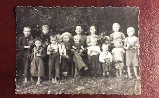 Дети ссыльных свидетелей Иеговы в поселке Искра Иркутской области (Василий Калин — второй слева в первом ряду, в белой рубашке и с цветами в руках)