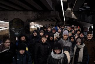 Украинцы толпятся под разрушенным мостом в ожидании эвакуации. Ирпень