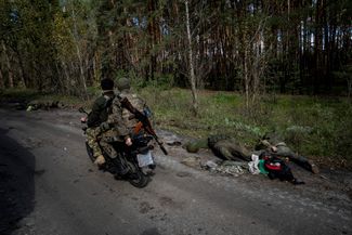 Солдаты ВСУ едут на мопеде мимо тел российских военных