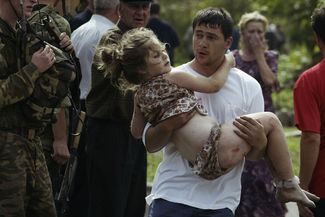 A volunteer carried a girl from the school, after the assault on the building