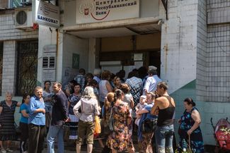 Residents of Donetsk line up in front of a DPR Central Bank branch for welfare payments.