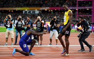 Бегуны Джастин Гэтлин и Усэйн Болт после забега на 100 метров на чемпионате мира по легкой атлетике. Лондон, 5 августа