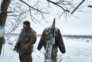 Украинский военный рядом с чучелом, сделанным из болванки кассетного снаряда